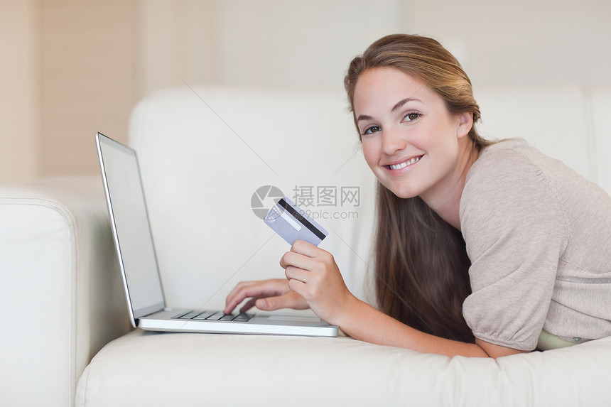 在线妇女购物休息电子商务信用卡电脑借方说谎互联网客厅女性闲暇图片