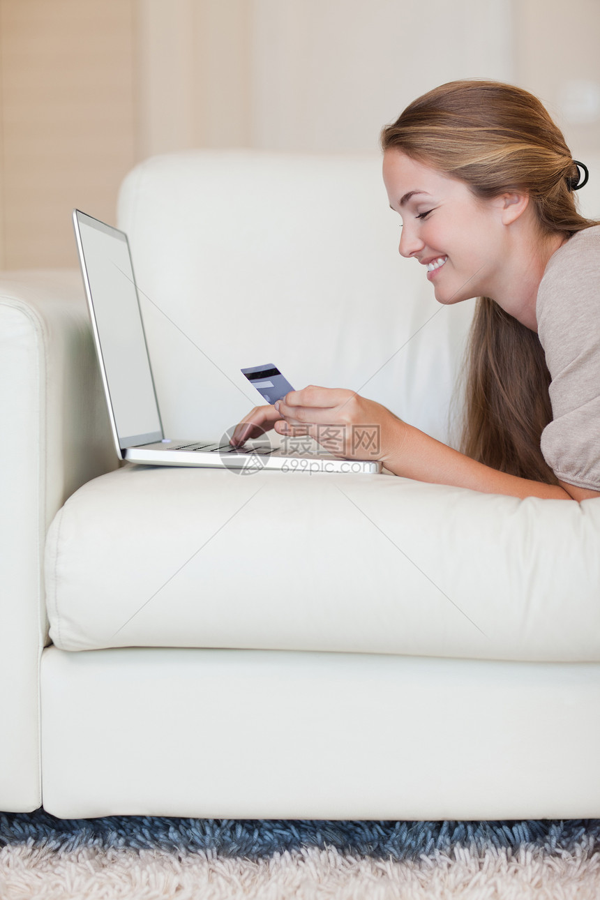 妇女在线购物的肖像沙发技术借方互联网沟通笔记本网络电子商务银行业闲暇图片