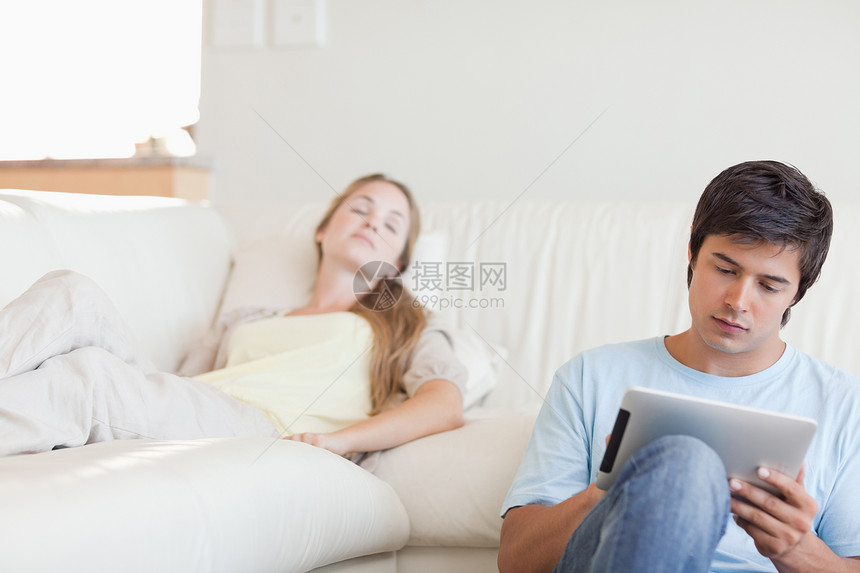 男人在女友睡着时使用平板电脑的人图片