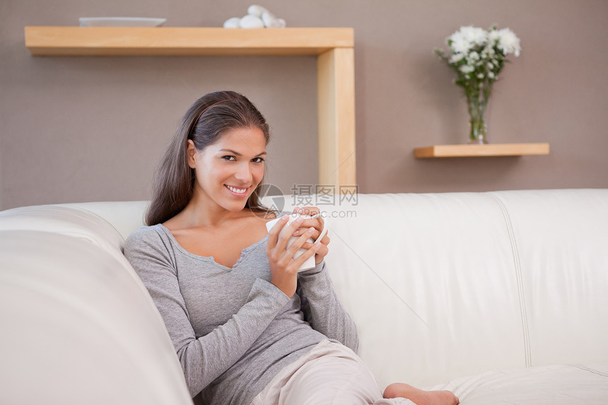 在沙发上喝咖啡的女人图片