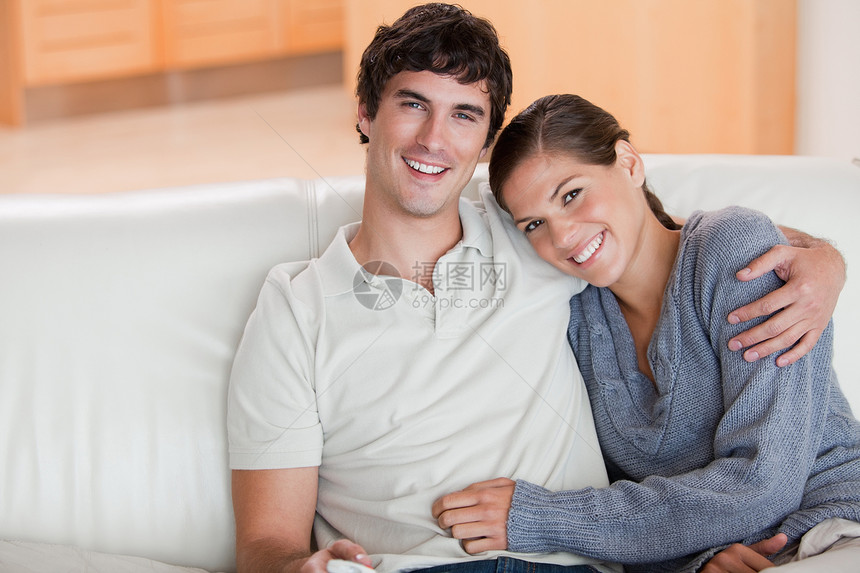 快乐的情侣在沙发上共度时光喜悦女性年轻人团结亲热电影控制电视拥抱娱乐图片
