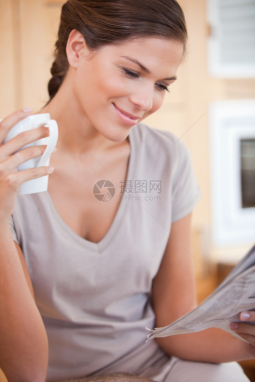 拿着茶杯看报纸的女人图片