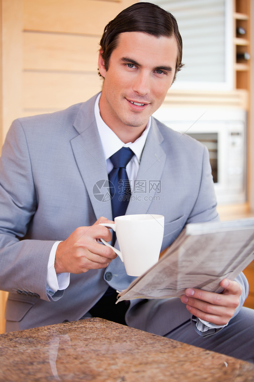 商务人士在厨房喝咖啡 看新闻 吃咖啡和看报纸图片