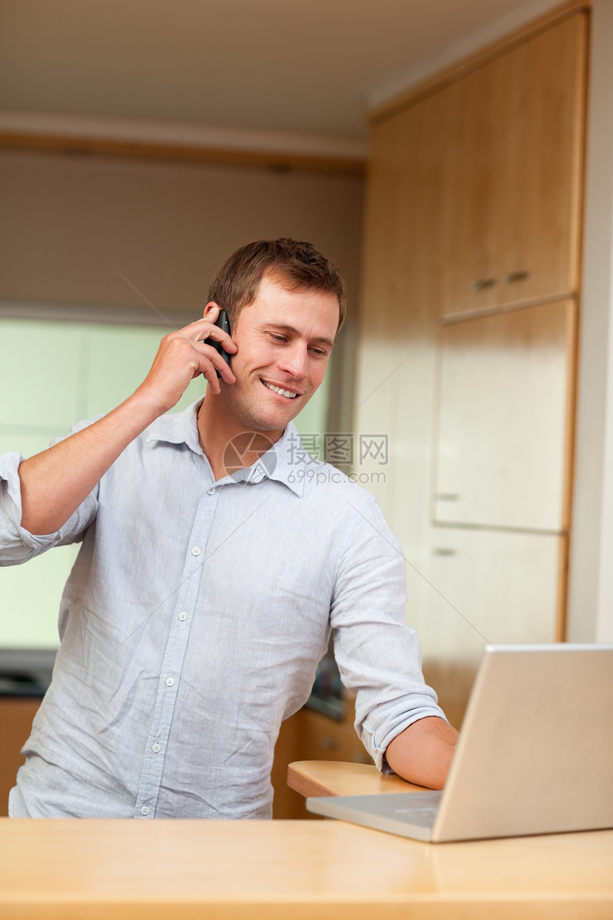 男用手机和膝上型电脑在厨房里图片