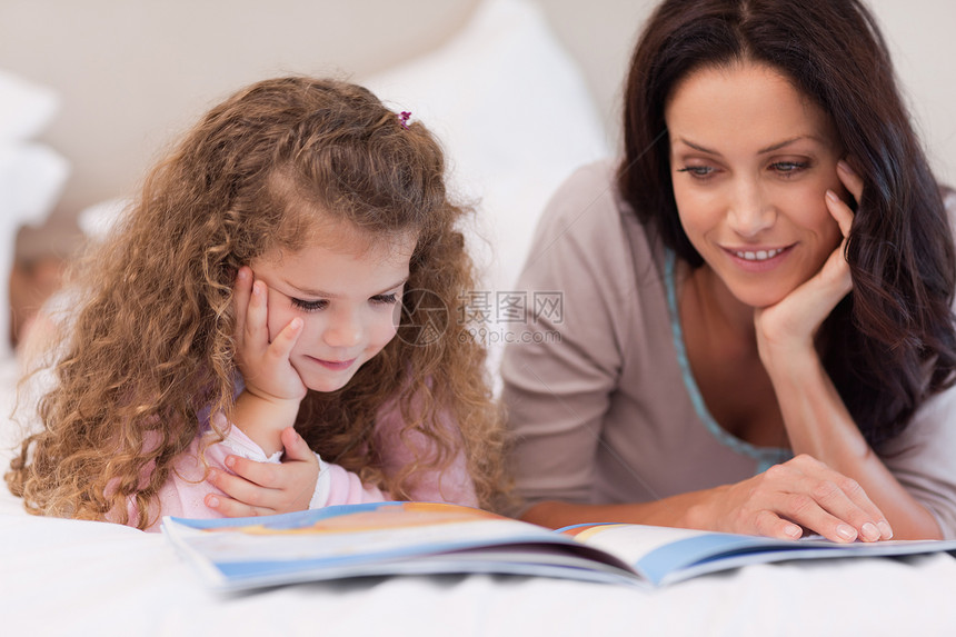 与母亲一起读睡前故事的小女孩图片