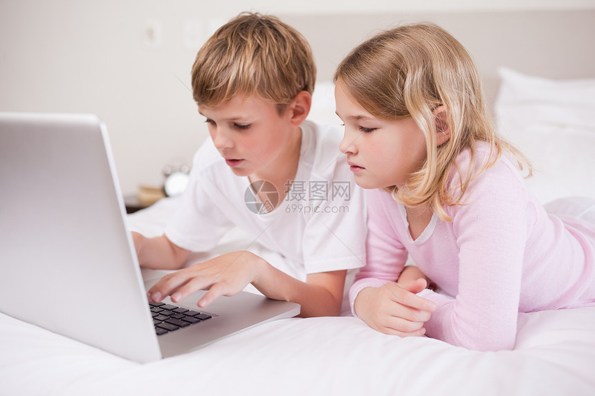 使用笔记本电脑的可爱儿童童年兄弟冲浪闲暇微笑兄弟姐妹教育享受技术幸福图片