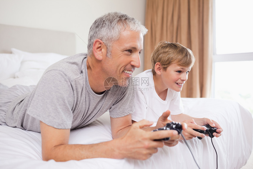 快乐的父亲和儿子在玩电子游戏图片