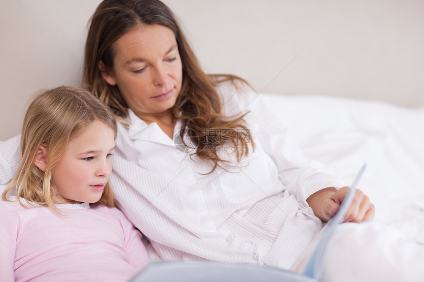 小女孩和妈妈在书上读书图片
