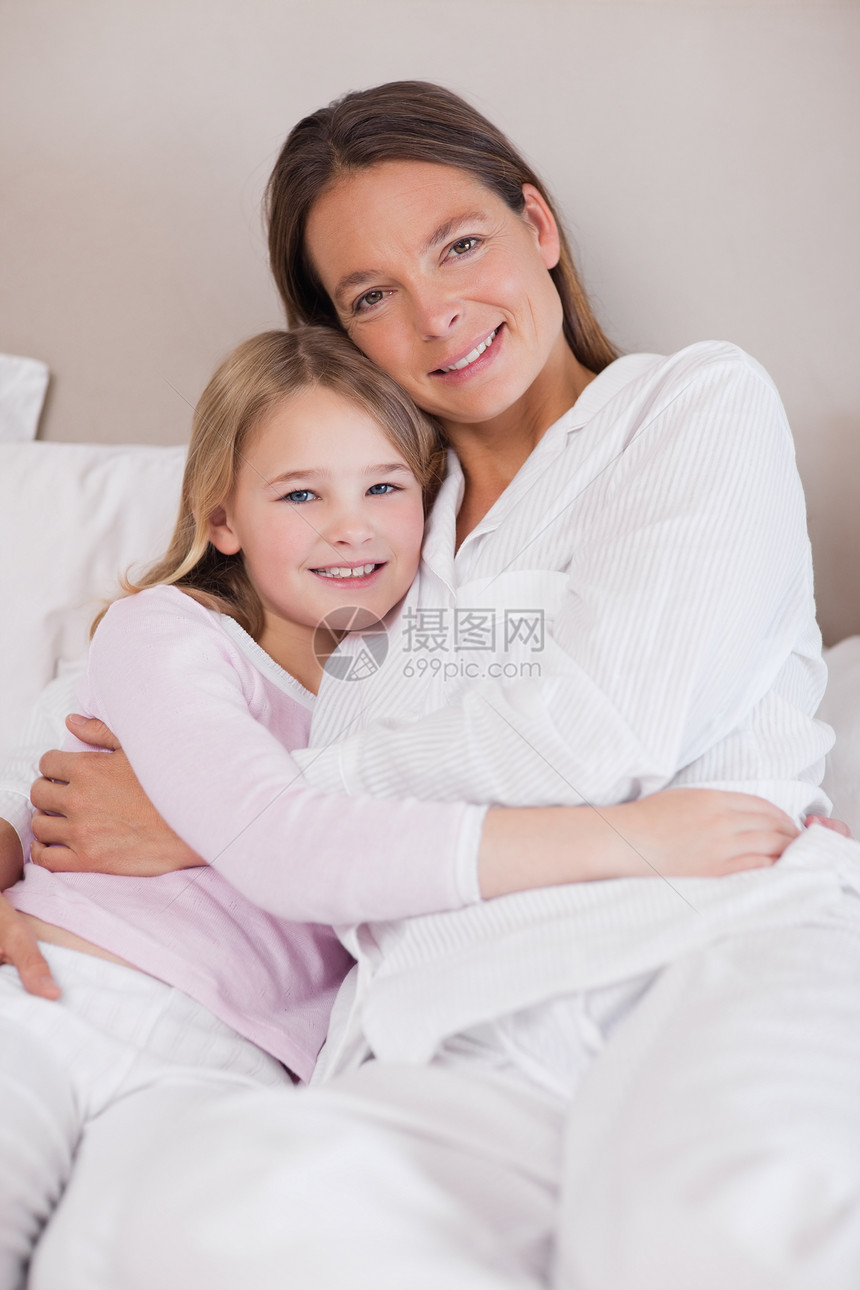 母亲和女儿抱抱的肖像亲热睡衣感情喜悦女孩们投标拥抱幸福家长童年图片