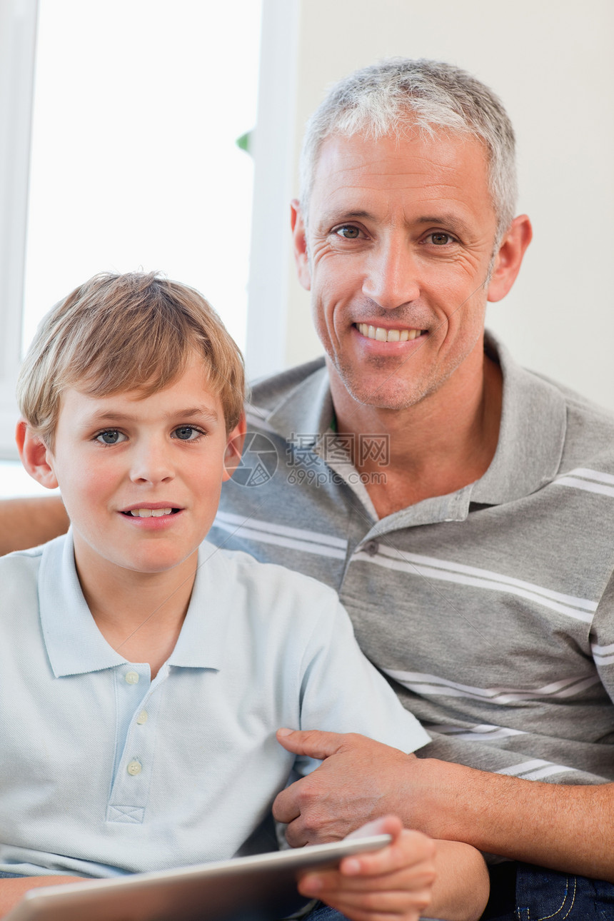 一位快乐的父亲和他的儿子使用平板电脑的肖像图片