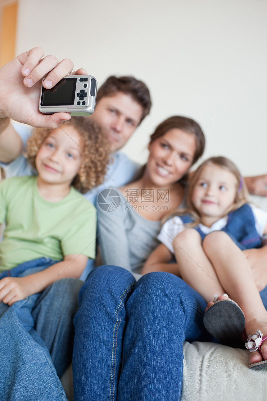 一个幸福家庭拍自己照片的肖像 被一个快乐家庭的肖像所描绘图片