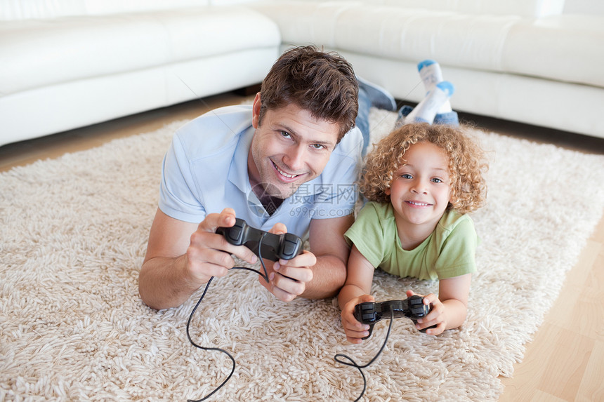 笑男孩和他父亲玩电子游戏图片