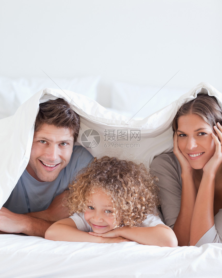 躺在床上的微笑的家庭毯子快乐孩子混血卧室喜悦被单童年母亲男生图片