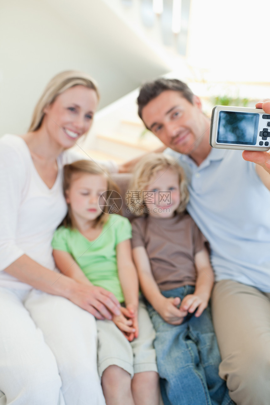 男人在沙发上拍家庭相片图片
