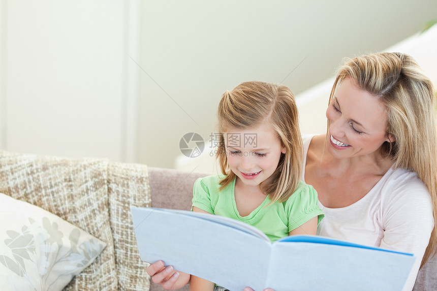 母亲和女儿读一本杂志图片