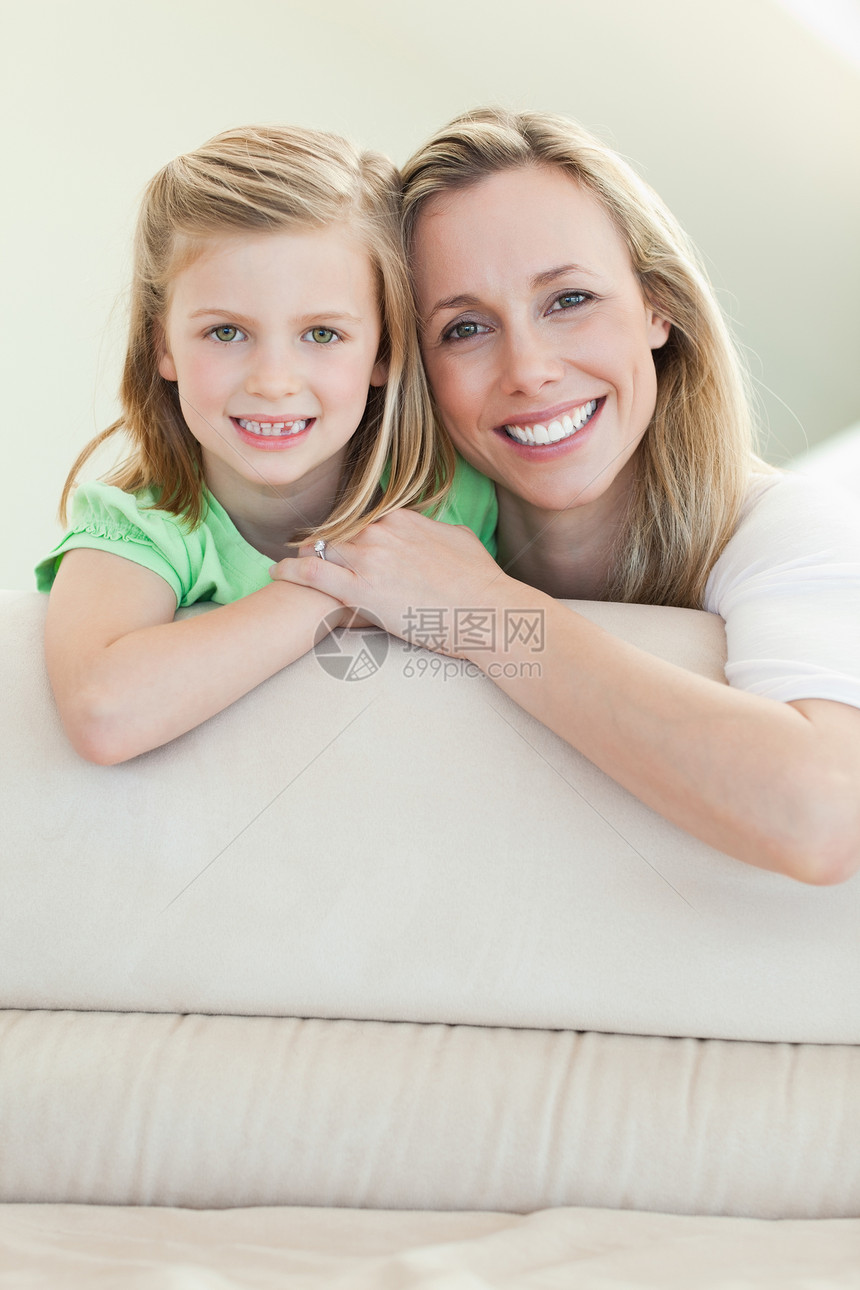 在沙发上微笑的快乐母亲和女儿图片