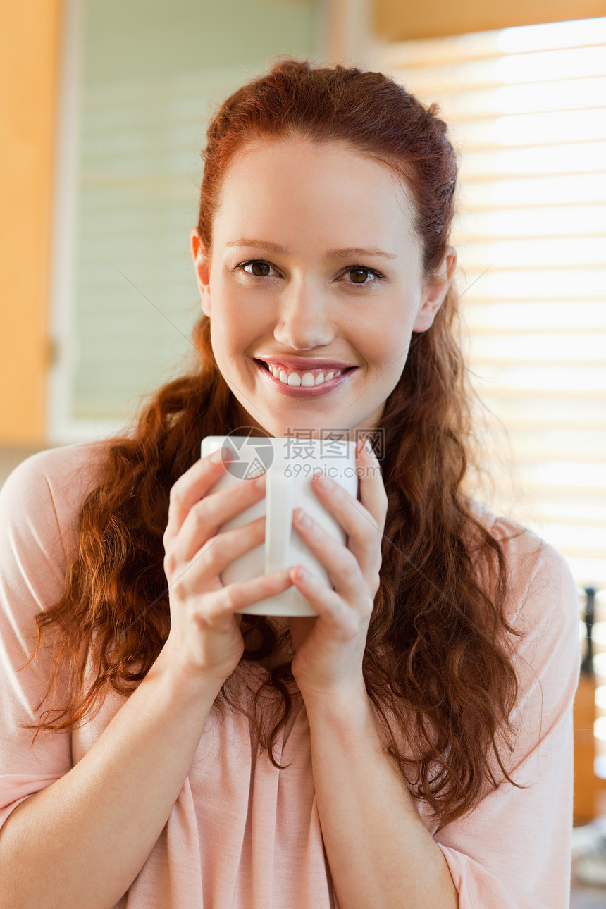 笑女人用咖啡喝着她的一杯咖啡图片