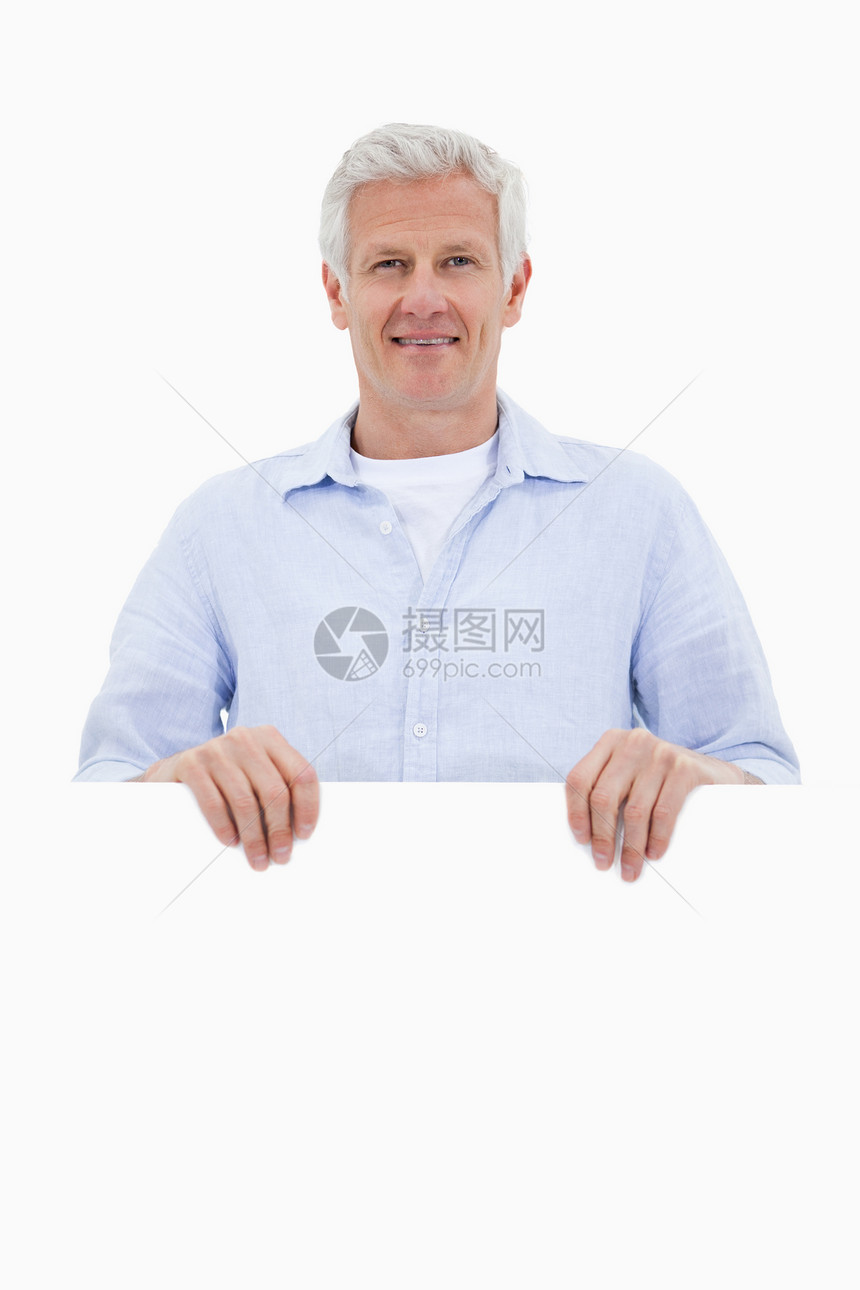 一个成熟男人的肖像 站在空白板后面图片