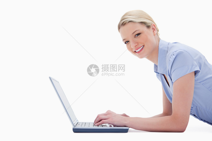 带着笔记本电脑微笑的女人的侧面视图图片