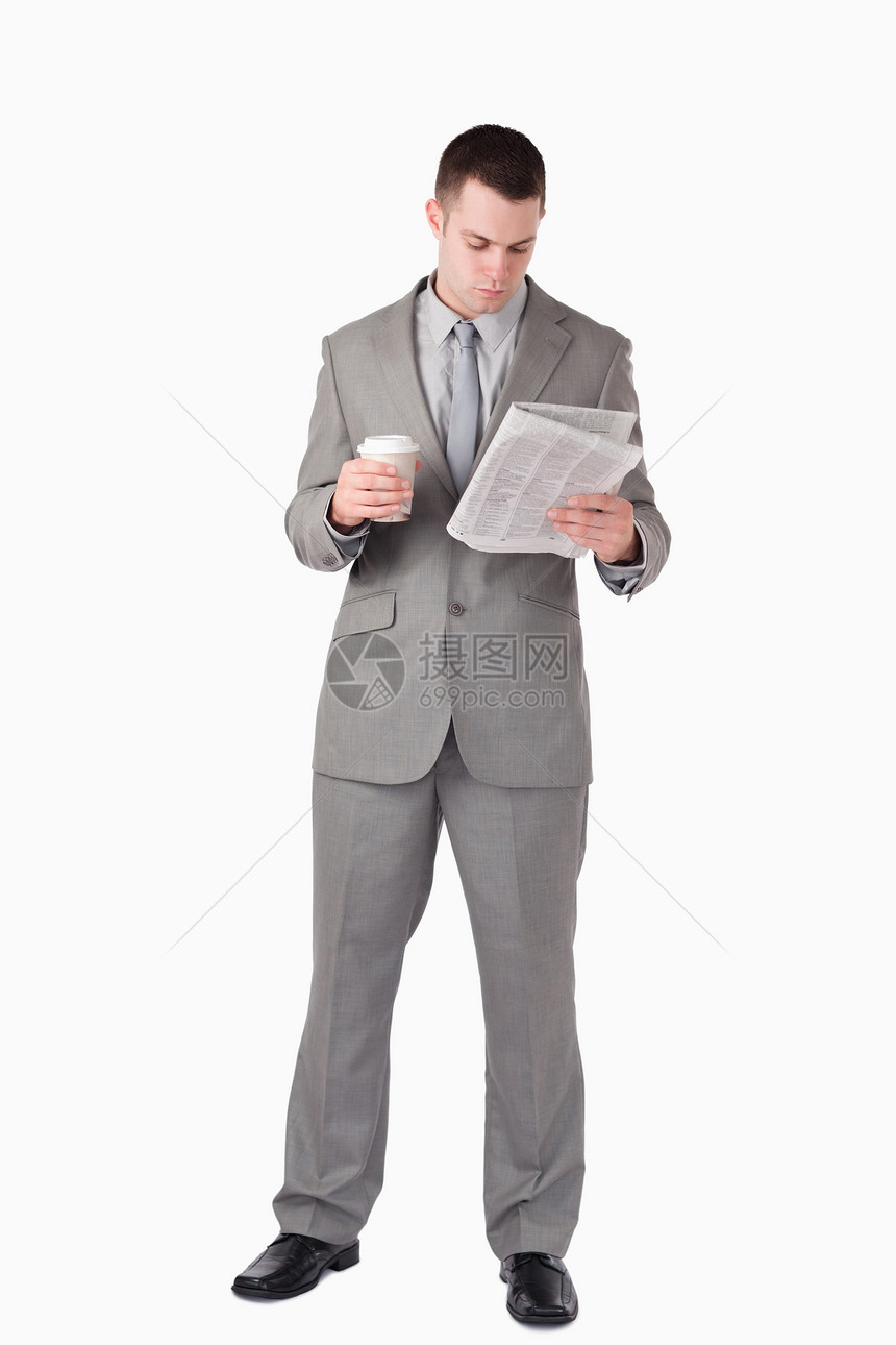 一名商务人士拿着杯子看新闻时的肖像办公室闲暇咖啡工作阅读经济成功职场套装工人图片