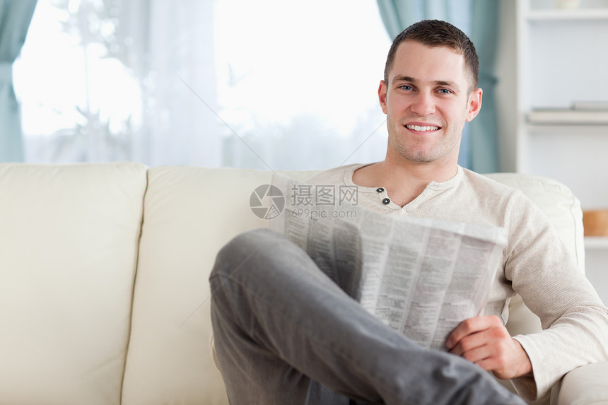 英俊男人看报纸衬衫休息室闲暇白色长椅房间沙发阅读家具外表图片
