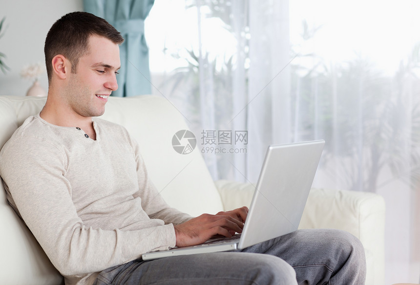 快乐的人在笔记本电脑上打字房间电子邮件冲浪工作互联网喜悦生活网络长椅沙发图片