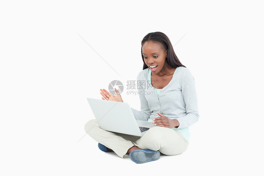 躺在地板上的年轻女人对她的笔记本电脑大喊大叫图片