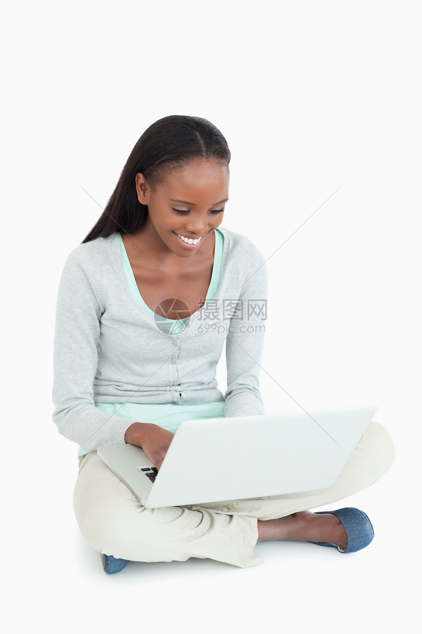 坐在地板上用笔记本电脑工作的笑女人图片