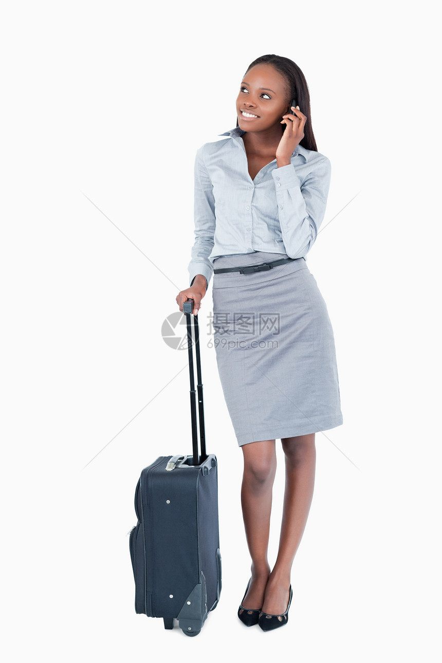一个可爱的女商务人士的肖像 带着一个手提箱做电话图片