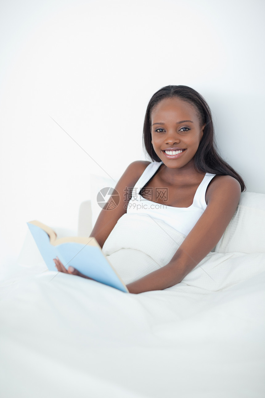 一个带着一本书的快乐女人的肖像图片