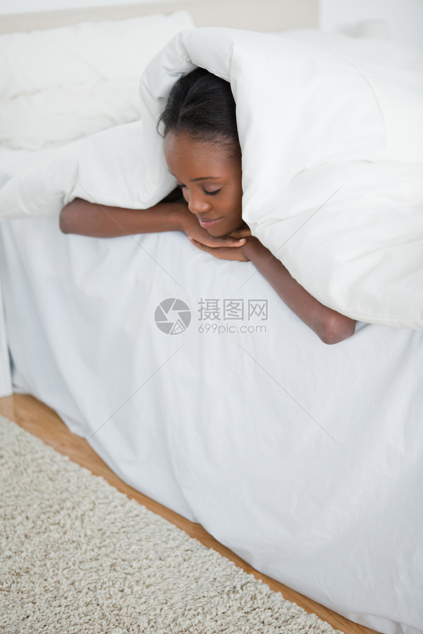 一个女人睡在她的床底下的肖像图片
