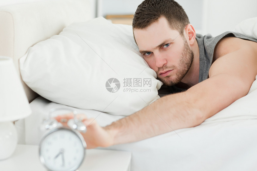 男人把闹钟关掉了家具手臂警报商业身体唤醒休息时间午睡铃声图片