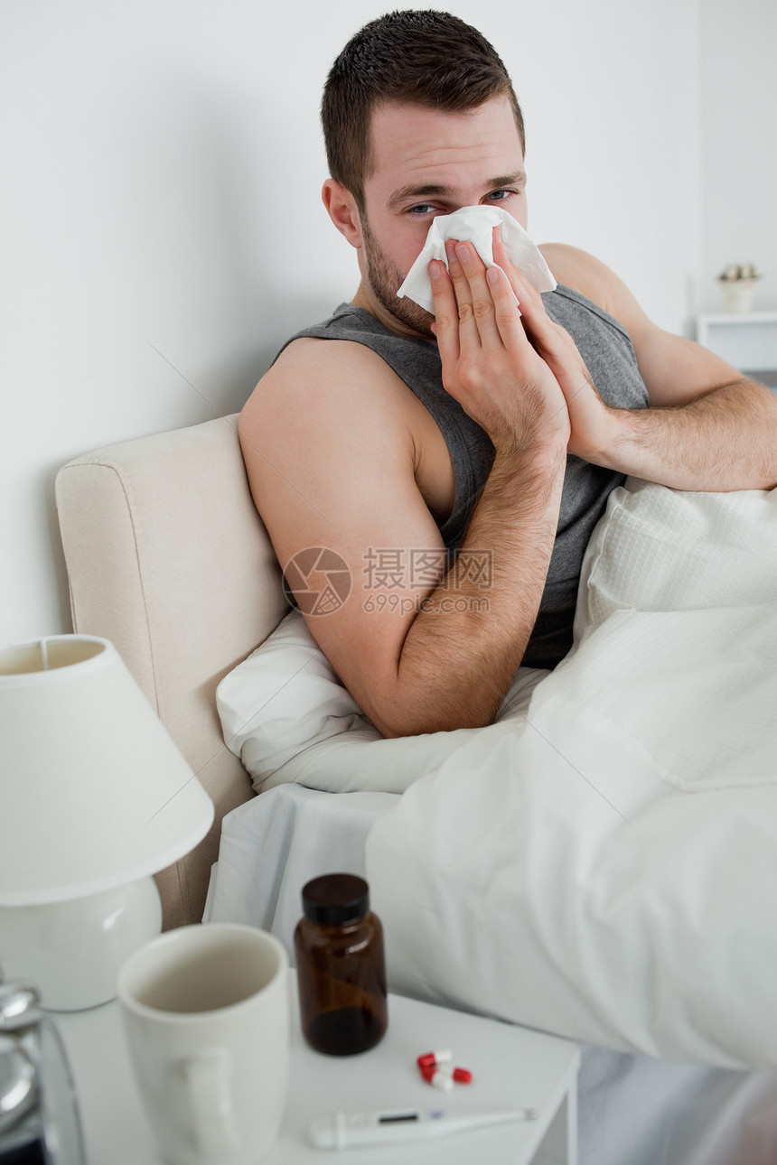 一个年轻人吹鼻涕的肖像疼痛流感细菌袖口鼻子杯子手帕发烧药品卫生图片