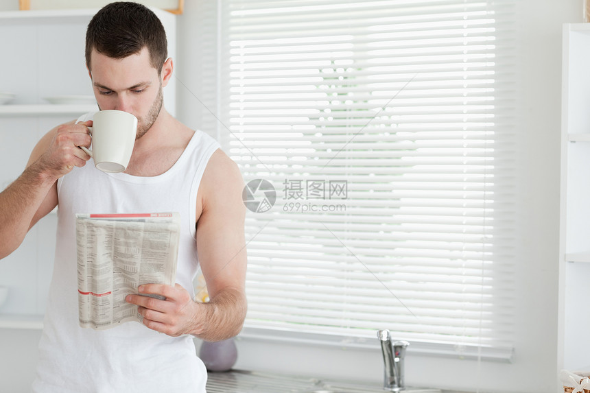 男人在看新闻时喝茶报纸房子食物年轻人咖啡杯子外表牛奶办公室早餐图片