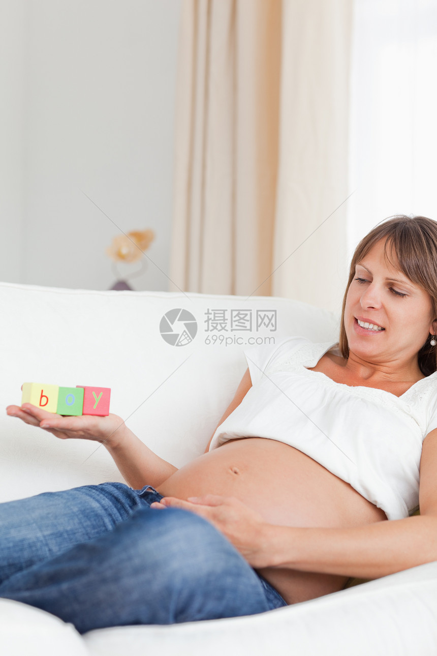 好漂亮的孕妇 玩木砖块和豪华的游戏怀孕享受妈妈女孩长椅父母男生妻子幸福玩具图片