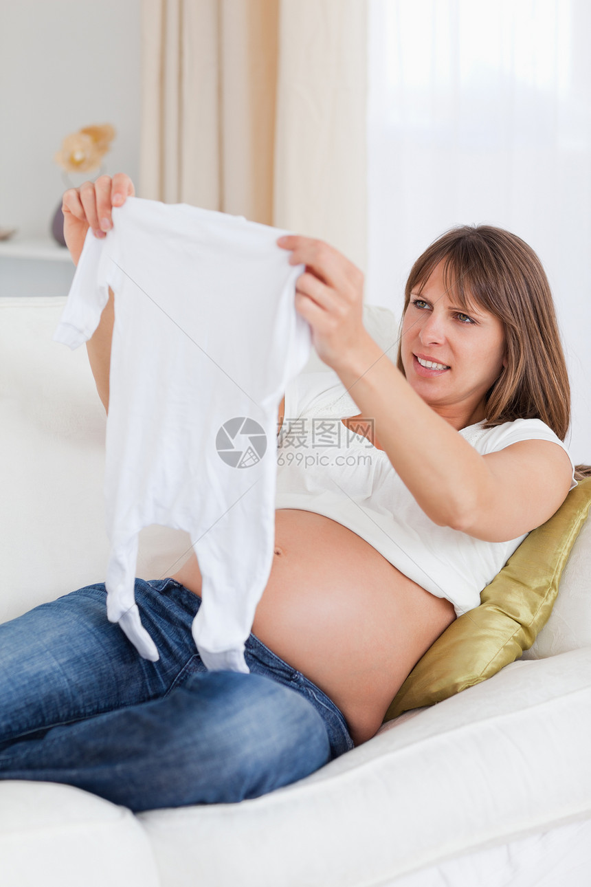 怀着婴儿的有吸引力的孕妇在躺着时长大图片