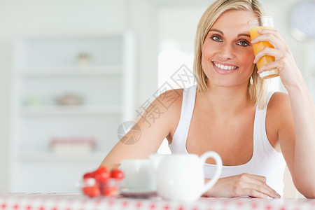 女人用橙汁杯子对着前额美丽高清图片素材