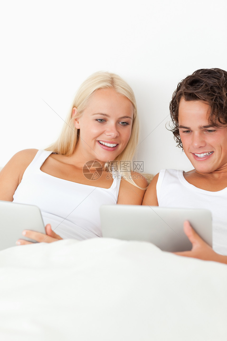 使用平板电脑微笑的一对夫妇的肖像图片