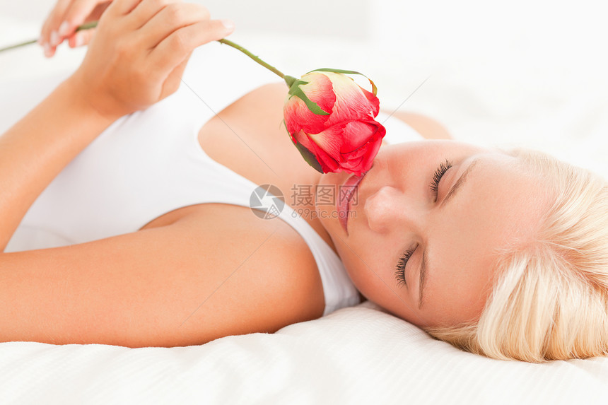 女人闻着花朵的香味女士玫瑰女性身体说谎情人金发女郎金发头发闲暇图片