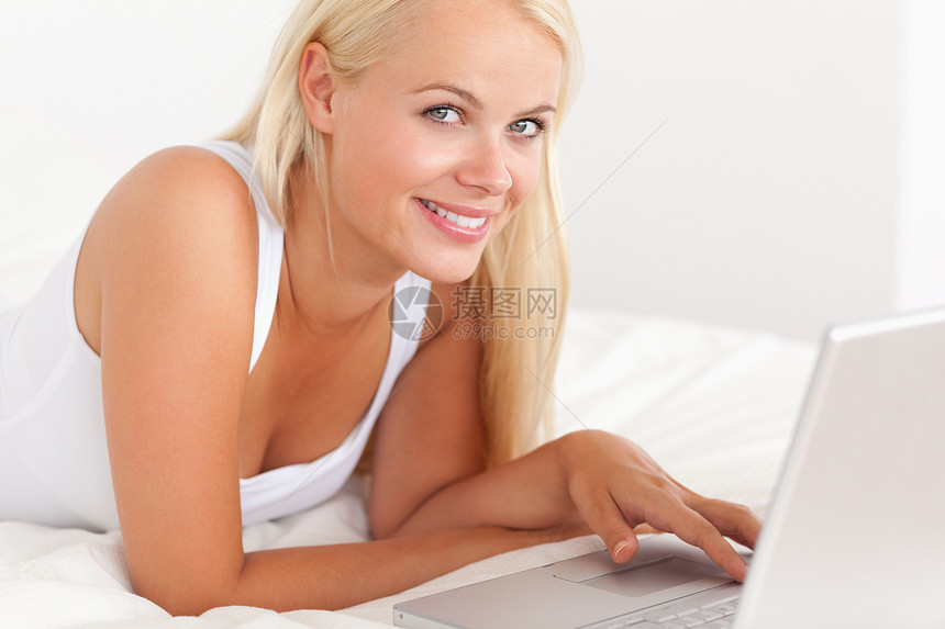 用笔记本电脑贴近一个女人沟通技术网络女性金发喜悦头发金发女郎互联网女士图片