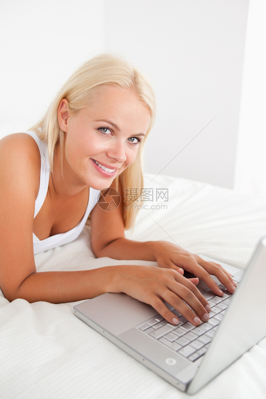 一个带着笔记本电脑的漂亮女人的肖像喜悦头发女士乐趣网络沟通金发女郎金发互联网房间图片