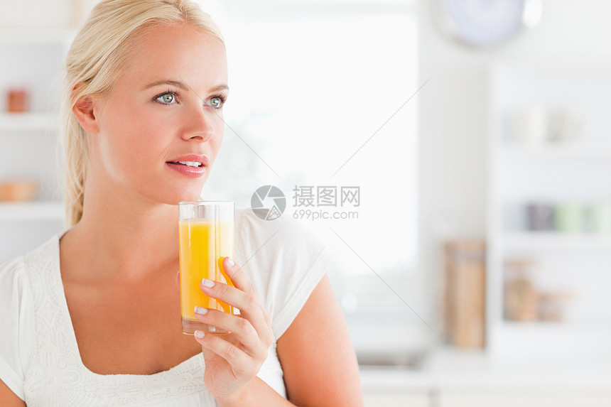 一个喝橙汁的女人的近身素食者喜悦女性水果女士头发果汁微笑饮料玻璃图片