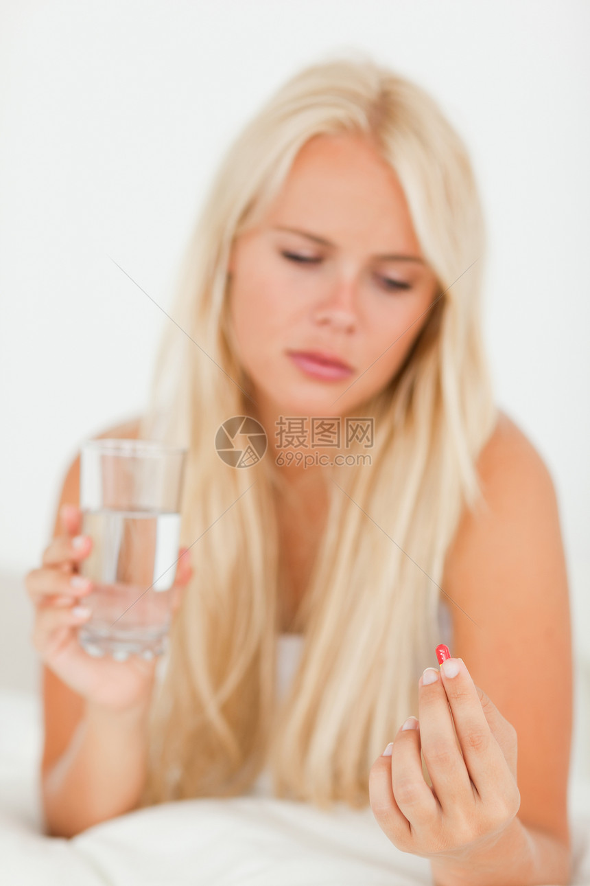 一个生病的女人吃药的肖像图片
