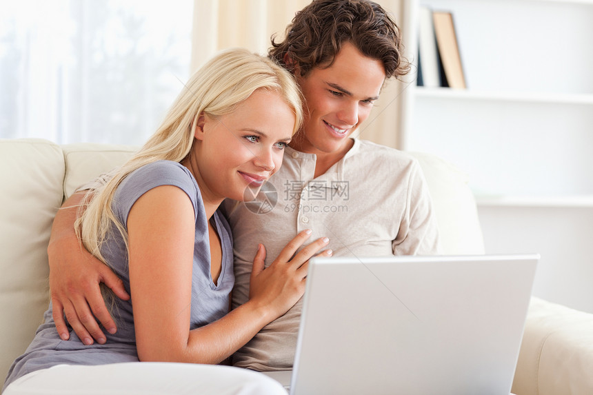 使用笔记本的可爱年轻夫妇生活女士乐趣微笑年轻人电脑恋人夫妻房子商业图片