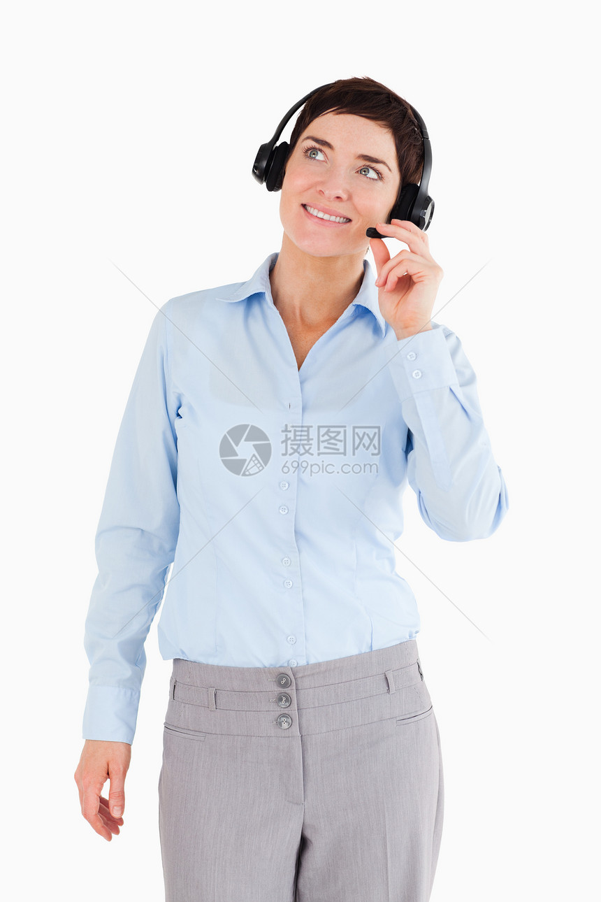 一个带着耳机的微笑的办公室工人的肖像图片