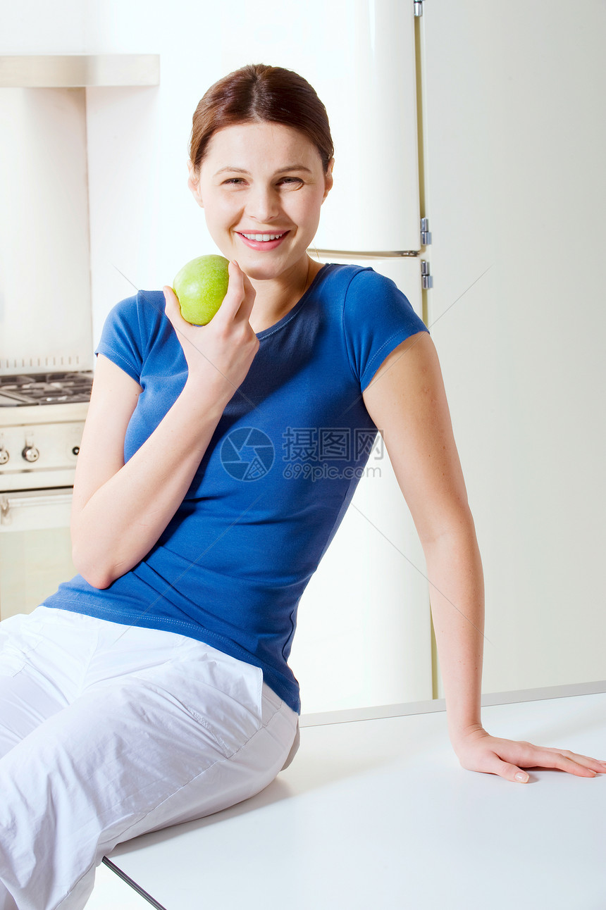 妇女吃苹果成人水果房子成年人女士厨房早餐微笑食物桌子图片