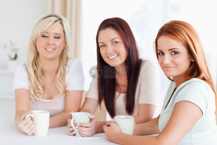 坐在桌边喝着咖啡的妇女图片