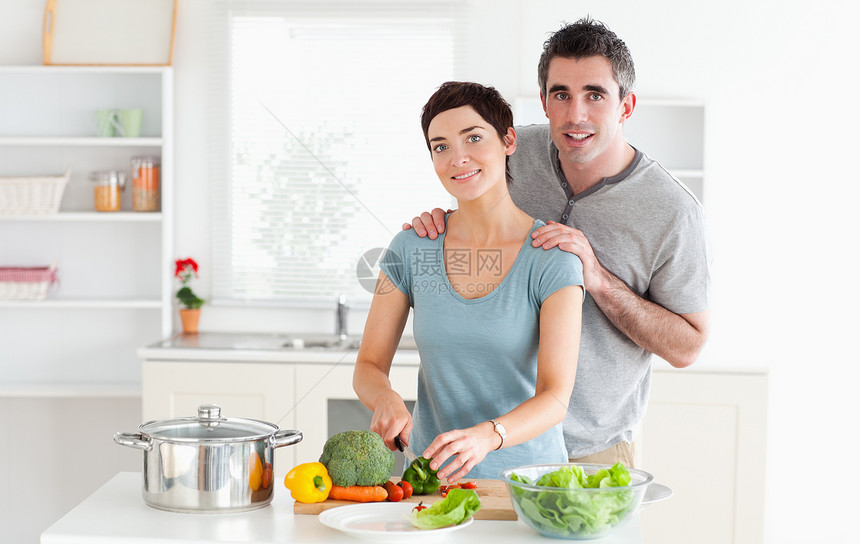 丈夫在妻子切菜时对其进行按摩 而她正在切蔬菜图片