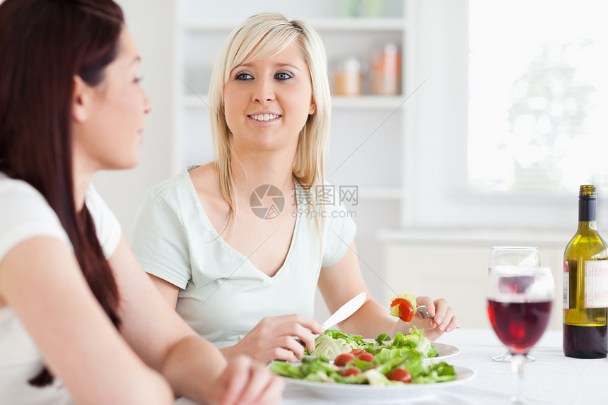 笑女人吃沙拉的肖像图片