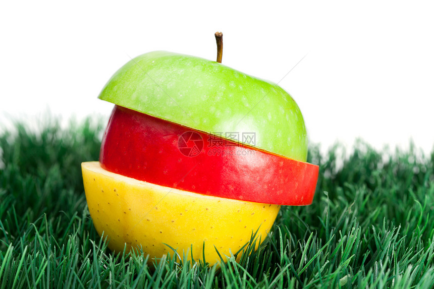 绿色 黄色和红苹果在草地上混合图片